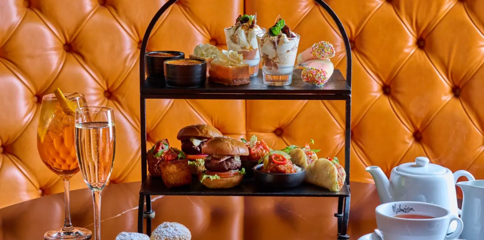 Afternoon tea delicacies against a leather sofa backdrop